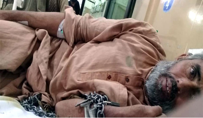 Handcuffed Muhammad Sultan suffering from a brain tumor